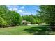 Spacious front yard featuring a brick house, a long driveway, and surrounding mature trees at 1590 W 7Th St, Newton, NC 28658
