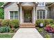Charming brick home featuring a covered front porch, manicured landscaping, and elegant windows at 1590 W 7Th St, Newton, NC 28658