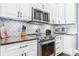 A well-appointed kitchen featuring white cabinets, stainless steel appliances, and granite countertops at 1590 W 7Th St, Newton, NC 28658