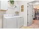 The laundry room boasts modern washer and dryer units with ample storage cabinets above at 1590 W 7Th St, Newton, NC 28658