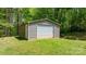 Durable metal outbuilding with roll-up door, perfect for storage, nestled on a green lawn at 1590 W 7Th St, Newton, NC 28658