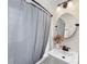 Bathroom featuring a pedestal sink, framed mirror, and bathtub with a gray shower curtain at 1716 Wickford Pl, Charlotte, NC 28203