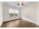 A bright bedroom with hardwood floors, a ceiling fan, and two large windows at 1716 Wickford Pl, Charlotte, NC 28203