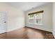 Bright bedroom with hardwood floors and a large window covered by a wood shade at 1716 Wickford Pl, Charlotte, NC 28203