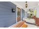 Charming front porch with brick base, hanging lantern, ceiling fan, and a wooden front door at 1716 Wickford Pl, Charlotte, NC 28203