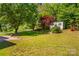 Manicured backyard showcasing the shed, trees, and lawn at 1807 Sugar Hollow Dr, Charlotte, NC 28214