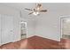Neutral bedroom with wood-look flooring, ceiling fan, and adjacent bathroom at 1807 Sugar Hollow Dr, Charlotte, NC 28214