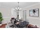 Staged dining room with a dark table set for four, modern light fixture, and view to entry and living room at 1807 Sugar Hollow Dr, Charlotte, NC 28214