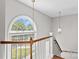 Bright foyer features a large arched window with sidelights, pendant lighting, and wooden railing at 1807 Sugar Hollow Dr, Charlotte, NC 28214