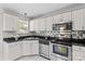 Charming kitchen featuring stainless steel appliances, granite countertops and bright white cabinets at 1807 Sugar Hollow Dr, Charlotte, NC 28214