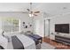 Spacious main bedroom with a ceiling fan, ensuite, and large window at 1807 Sugar Hollow Dr, Charlotte, NC 28214