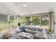 Bright sunroom with many windows offering views of the yard, a large couch, and patterned rug at 1807 Sugar Hollow Dr, Charlotte, NC 28214