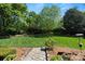 Well-manicured backyard featuring a stone pathway, vibrant greenery, and serene landscaping at 1816 5Th Nw St, Hickory, NC 28601