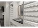 A basement wet bar area with a granite countertop sink, a mirror, and surrounding wine rack at 1816 5Th Nw St, Hickory, NC 28601
