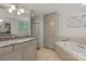 Well-lit bathroom with dual granite sinks, tiled floors, a bathtub, and built-in storage unit at 1816 5Th Nw St, Hickory, NC 28601
