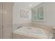 Bathroom with an oversized tub surrounded by tile, bright window with shutter, and a built-in storage unit at 1816 5Th Nw St, Hickory, NC 28601