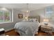 Comfortable bedroom with a padded headboard, chandelier, and hardwood floors at 1816 5Th Nw St, Hickory, NC 28601