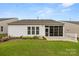 Beautifully landscaped backyard featuring a well-manicured lawn, garden beds, and a view of the sunroom at 20135 Dovekie Ln, Fort Mill, SC 29707