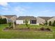 Manicured lawn, lush landscaping, and a view of the home's back facade, including the screened porch at 20135 Dovekie Ln, Fort Mill, SC 29707