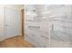 Modern glass enclosed shower with marble walls and floors, wood look tile floors, and a shower door at 20135 Dovekie Ln, Fort Mill, SC 29707