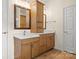 Bathroom with wood cabinets, double sinks with marble countertops, wood floors, and a door at 20135 Dovekie Ln, Fort Mill, SC 29707