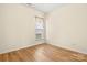 A bright bedroom featuring hardwood floors, natural light from a window, and neutral colored walls at 20135 Dovekie Ln, Fort Mill, SC 29707