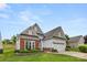 Inviting one-story home featuring a brick and siding facade, lush lawn, and convenient two-car garage at 20135 Dovekie Ln, Fort Mill, SC 29707