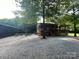 Exterior image of community building, with picnic tables and a gravel parking lot surrounded by a lush landscape at 20135 Dovekie Ln, Fort Mill, SC 29707