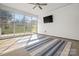 Enclosed sunroom with a ceiling fan, TV, and large windows offering views of the lush backyard at 20135 Dovekie Ln, Fort Mill, SC 29707