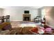 Open living room features a brick fireplace, hardwood floors, and comfortable seating arrangement at 2113 Killarney Pl, Charlotte, NC 28262