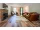 Bright living room with a brick fireplace, hardwood floors, and comfortable leather sofa at 2113 Killarney Pl, Charlotte, NC 28262