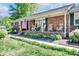 Welcoming brick porch adorned with rocking chairs and patriotic decor, surrounded by manicured landscaping at 212 Brookwood Dr, Salisbury, NC 28146