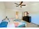 Bright bedroom features neutral walls, ceiling fan, and dark wood dresser with decorative orchid at 2141 Talbert Ct, Charlotte, NC 28214