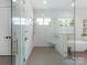 A bright bathroom showcasing a frameless glass shower, soaking tub, and stylish gold fixtures at 2343 Vernon Dr, Charlotte, NC 28211