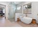 Bathroom featuring a soaking tub, a walk-in shower with glass door and an exterior window at 2343 Vernon Dr, Charlotte, NC 28211