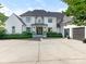 Stunning white brick two-story home with a black roof, manicured landscaping, and a spacious concrete driveway at 2343 Vernon Dr, Charlotte, NC 28211