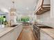 Bright kitchen with stainless steel appliances, marble countertops, and gold fixtures open to the dining area at 2343 Vernon Dr, Charlotte, NC 28211