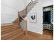 Elegant staircase with hardwood steps, black metal railings, and a modern art piece at 2343 Vernon Dr, Charlotte, NC 28211