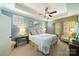 Light filled bedroom with blue walls, tray ceiling, fan and view of decorated wall at 2355 Crockett Park Pl, Charlotte, NC 28203
