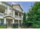 Charming townhome with two stories, front porch, balcony, fenced yard, and neutral-colored siding at 2355 Crockett Park Pl, Charlotte, NC 28203