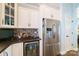 A modern kitchen featuring stainless steel appliances, white cabinets, and stylish brick backsplash at 2355 Crockett Park Pl, Charlotte, NC 28203