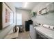 Well-equipped laundry room with washer, dryer, shelving, and natural light from window at 2355 Crockett Park Pl, Charlotte, NC 28203