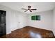 Cozy bedroom featuring hardwood floors, a ceiling fan, and a window overlooking a lush green yard at 2601 Pinewood Rd, Gastonia, NC 28054