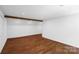 Bedroom featuring hardwood floors, a decorative beam, and a spacious layout, creating a cozy and inviting atmosphere at 2601 Pinewood Rd, Gastonia, NC 28054