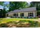 Well-maintained home with white facade, black shutters, manicured lawn, complemented by lush greenery and a welcoming entrance at 2601 Pinewood Rd, Gastonia, NC 28054