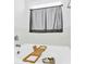 Relaxing bathtub with marble tile surround, a bamboo tray, and natural light from the window at 3153 Pinehills Way, Mount Holly, NC 28120