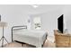 Minimalist bedroom features a simple bed, neutral decor, and ample natural light from the window at 3153 Pinehills Way, Mount Holly, NC 28120