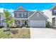 Charming two-story home with a well-manicured lawn and inviting two-car garage at 3153 Pinehills Way, Mount Holly, NC 28120