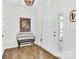 Bright foyer with hardwood floors, a decorative bench, and a view of the front door at 3153 Pinehills Way, Mount Holly, NC 28120