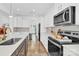 Well-lit kitchen featuring white cabinets, subway tile backsplash, and stainless steel appliances at 3153 Pinehills Way, Mount Holly, NC 28120